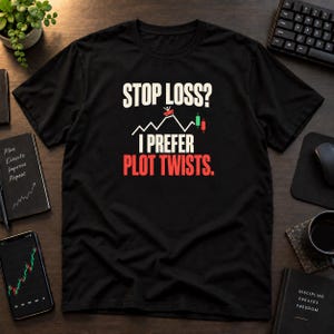 Op de afbeelding: Een zwart t-shirt met korte mouwen voorzien van de witte tekst STOP LOSS? boven een grafiek van een beurskoers met een klein figuurtje op een achtbaan, gevolgd door de tekst I PREFER in het wit en PLOT TWISTS. in rode letters.
