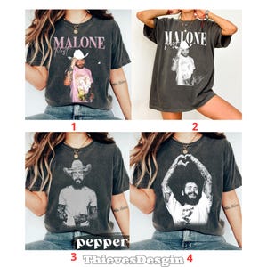 May include: A collection of four charcoal gray short-sleeve t-shirts featuring graphic prints of Post Malone. Each shirt displays different photographic portraits of the artist, some with cowboy hats, and the text MALONE in bold lettering.