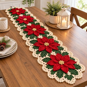 May include: A long, rectangular crochet table runner featuring a repeating pattern of vibrant red poinsettia flowers with yellow centers, surrounded by dark green leaves and finished with a cream-colored scalloped lace border.