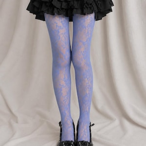 Peut inclure: Collants en dentelle bleu pervenche avec un motif floral détaillé, portés avec une mini-jupe noire à volants et des chaussures noires à lacets et à bout pointu. Les collants présentent une texture semi-transparente avec un motif complexe.