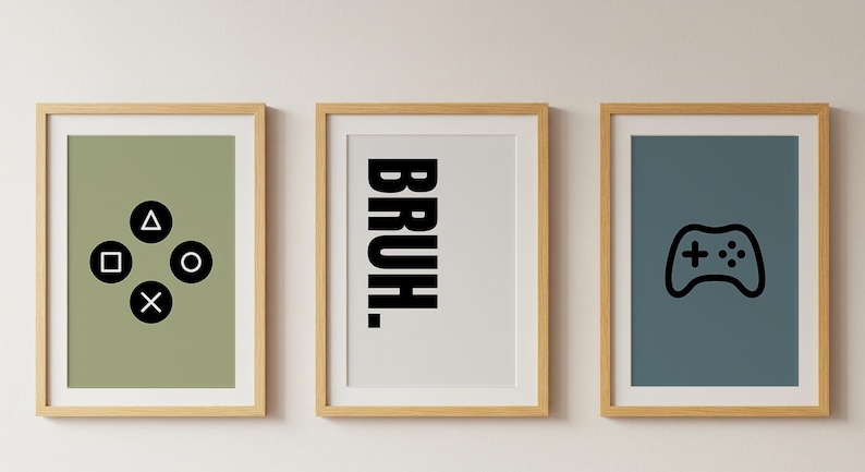 May include: Three framed prints with a gaming theme. One print features black shapes, another says "BRUH" in bold letters, and the third shows a black game controller icon. The frames are light brown, and the backgrounds are green, white, and blue.