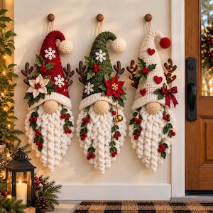 May include: Three hanging crochet gnome decorations with long white beards, pointed hats in red, green, and cream, adorned with crocheted snowflakes, poinsettias, hearts, holly berries, and brown antlers. Each gnome features a round nose and a loop.