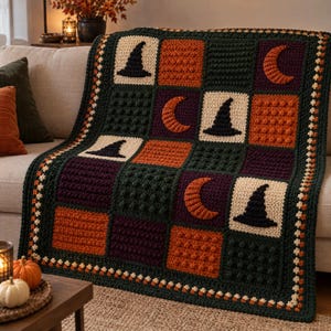 May include: A rectangular crochet blanket featuring a grid of alternating squares in dark green, orange, and purple. The squares display textured bobble stitches or intarsia patterns of black witch hats and orange crescent moons.