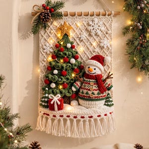 May include: A cream-colored crocheted wall hanging featuring a green Christmas tree with red and white ornaments, a yellow star topper, a snowman wearing a red hat and scarf, a red gift box, and white snowflakes, finished with a fringe bottom.