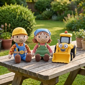 Puede incluir: Tres muñecos de ganchillo hechos a mano que incluyen un personaje masculino con casco amarillo y peto azul, un personaje femenino con pañuelo azul y vestido verde, y un vehículo de construcción amarillo con ruedas negras y pala.