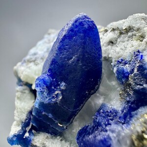 Cristalli di afghanite blu fluorescenti a terminazione completa con matrice di pirite e calcite (184 grammi)