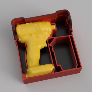 May include: A red and black moulded plastic storage insert featuring a custom-shaped cavity for a yellow power tool. The tray includes a dedicated recessed section for the tool body and an adjacent rectangular compartment for a battery pack.