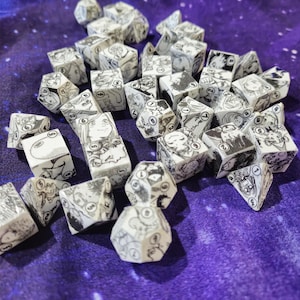 May include: A collection of white dice with black manga-style illustrations on each face. The dice are scattered on a purple background with white speckles.