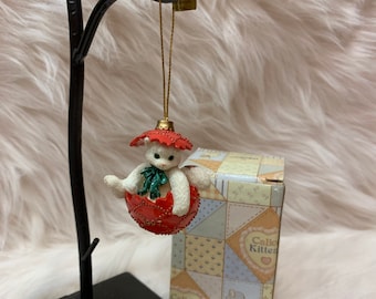 Calico Kätzchen Kätzchen sitzend in Broken Ornament