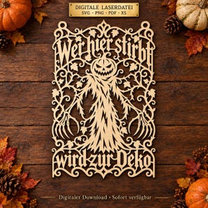 May include: A light-colored, laser-cut wooden wall hanging featuring a central scarecrow figure with a pumpkin head, surrounded by intricate vine and leaf patterns. The text "Wer hier stirbt wird zur Deko" is carved into the top and bottom sections.