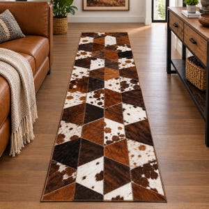 Puede incluir: Una alfombra de pasillo rectangular larga con un patrón geométrico de paneles hexagonales cosidos. Los paneles están compuestos de piel de vaca en varios tonos de marrón, negro y blanco, creando una apariencia texturizada y tonal.