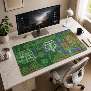 May include: A large rectangular desk mat featuring a colorful pixel art map design with green landscapes, blue rivers, and a central castle structure. The mat is positioned on a white marble-patterned desk surface in front of a computer monitor.