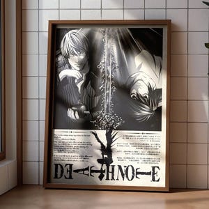 Peut inclure: Une affiche encadrée en noir et blanc représentant les personnages Light Yagami et L de Death Note. L'illustration montre une épée centrale, une pomme et le logo Death Note en bas avec des blocs de texte en anglais et en japonais.