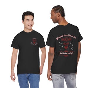 Puede incluir: Una camiseta negra con un pequeño gráfico de cabeza de cabra roja en el pecho con el texto "live deliciously". La parte posterior muestra un gráfico más grande de cabeza de cabra roja, símbolos celestiales y el texto "Wouldst thou like to live...deliciously?"
