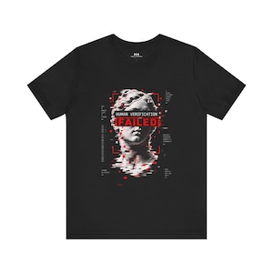 May include: A black short-sleeve t-shirt featuring a white classical statue head graphic with red digital glitch effects. The text reads HUMAN VERIFICATION FAILED across the eyes, surrounded by small technical text and red square accents.