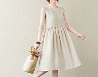 May include: A sleeveless, beige linen dress with a gathered skirt. The dress is knee-length and has a round neckline.