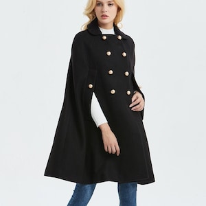 May include: A black double-breasted cape with gold buttons. The cape is knee-length and has a collar.
