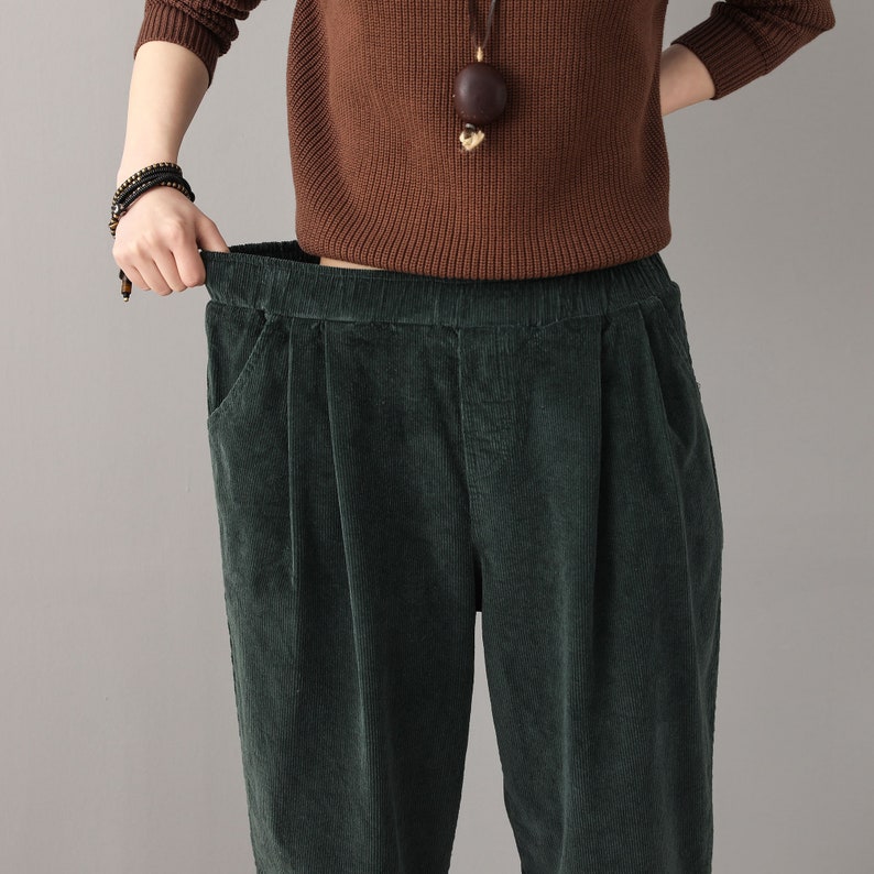 May include: Green corduroy pants with a wide leg and a high waist. The pants have a relaxed fit and are made of a soft, comfortable fabric.