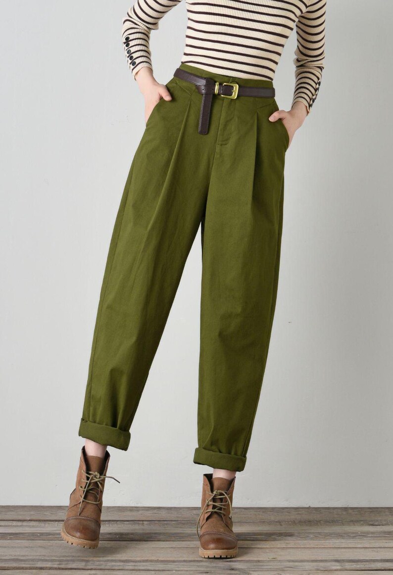 Op de afbeelding: Groene broek met hoge taille, een bruine leren riem en bruine leren laarzen.