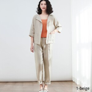 Pode incluir: Um conjunto de cal&ccedil;as de linho bege com uma jaqueta de colarinho e cal&ccedil;as compridas. A jaqueta tem dois bolsos e as cal&ccedil;as t&ecirc;m uma perna reta.