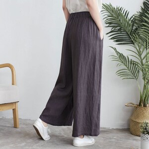 Puede incluir: Pantal&oacute;n de pierna ancha en color gris oscuro, hecho de tela de lino. El pantal&oacute;n tiene un corte holgado y una cintura alta.