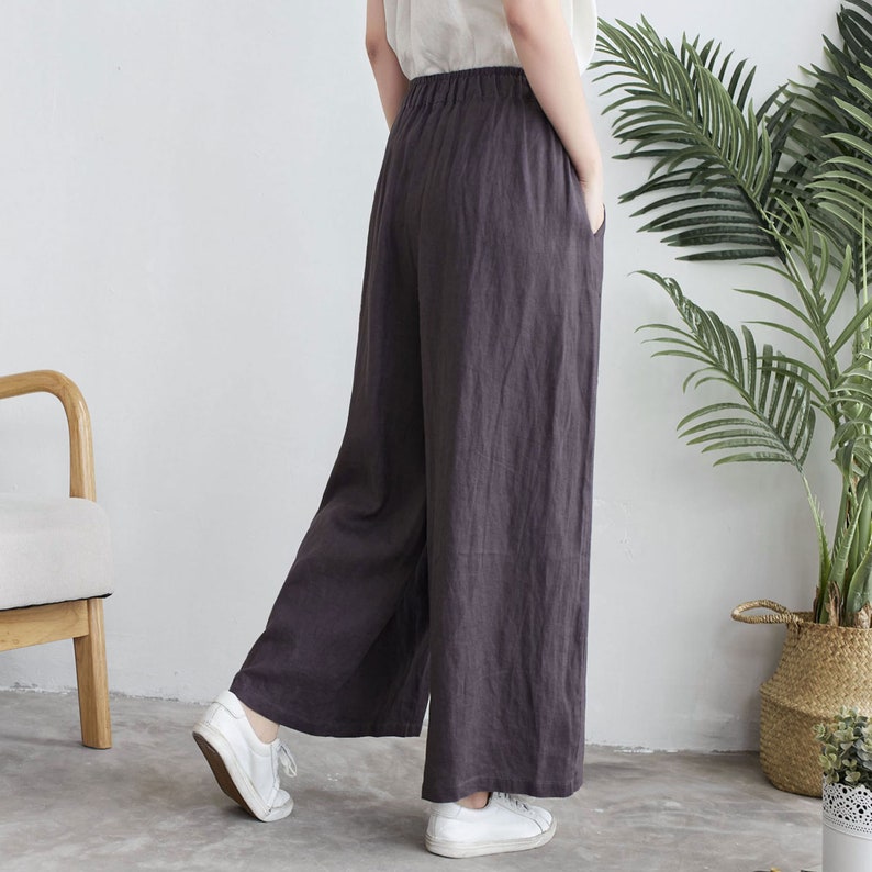 Puede incluir: Pantal&oacute;n de pierna ancha en color gris oscuro, hecho de tela de lino. El pantal&oacute;n tiene un corte holgado y una cintura alta.