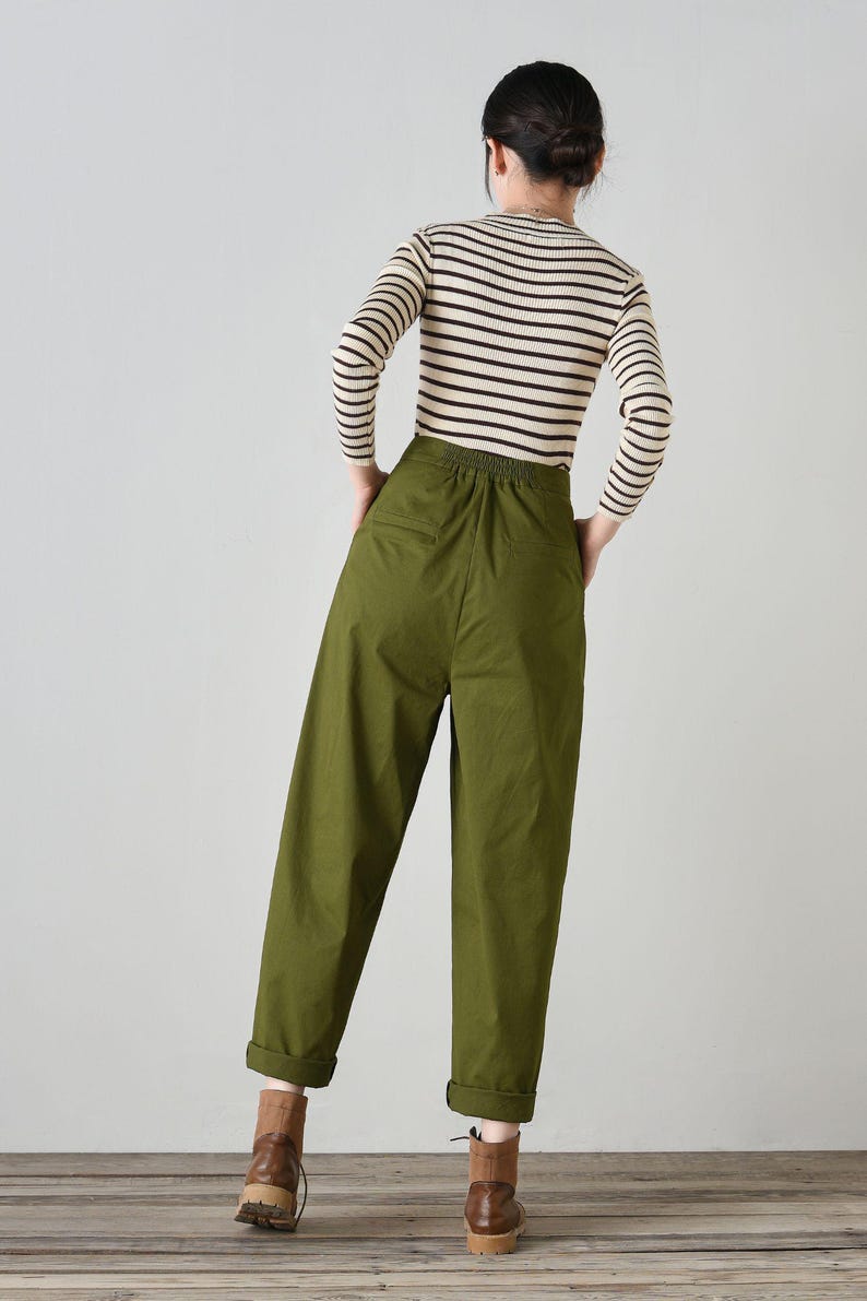 Op de afbeelding: Een olijfgroene, hoge broek met een trekkoord in de taille en gezoomde pijpen. De broek is gemaakt van een lichtgewicht stof en heeft een ontspannen pasvorm.