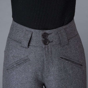 Puede incluir: Pantal&oacute;n de lana gris con cierre de doble bot&oacute;n y dos bolsillos delanteros.