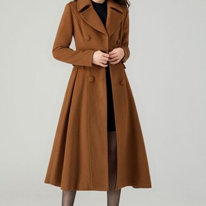 May include: A long brown double-breasted coat with a flared skirt. The coat has a classic collar and button closures.