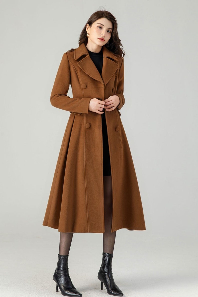 May include: A long brown double-breasted coat with a flared skirt. The coat has a classic collar and button closures.