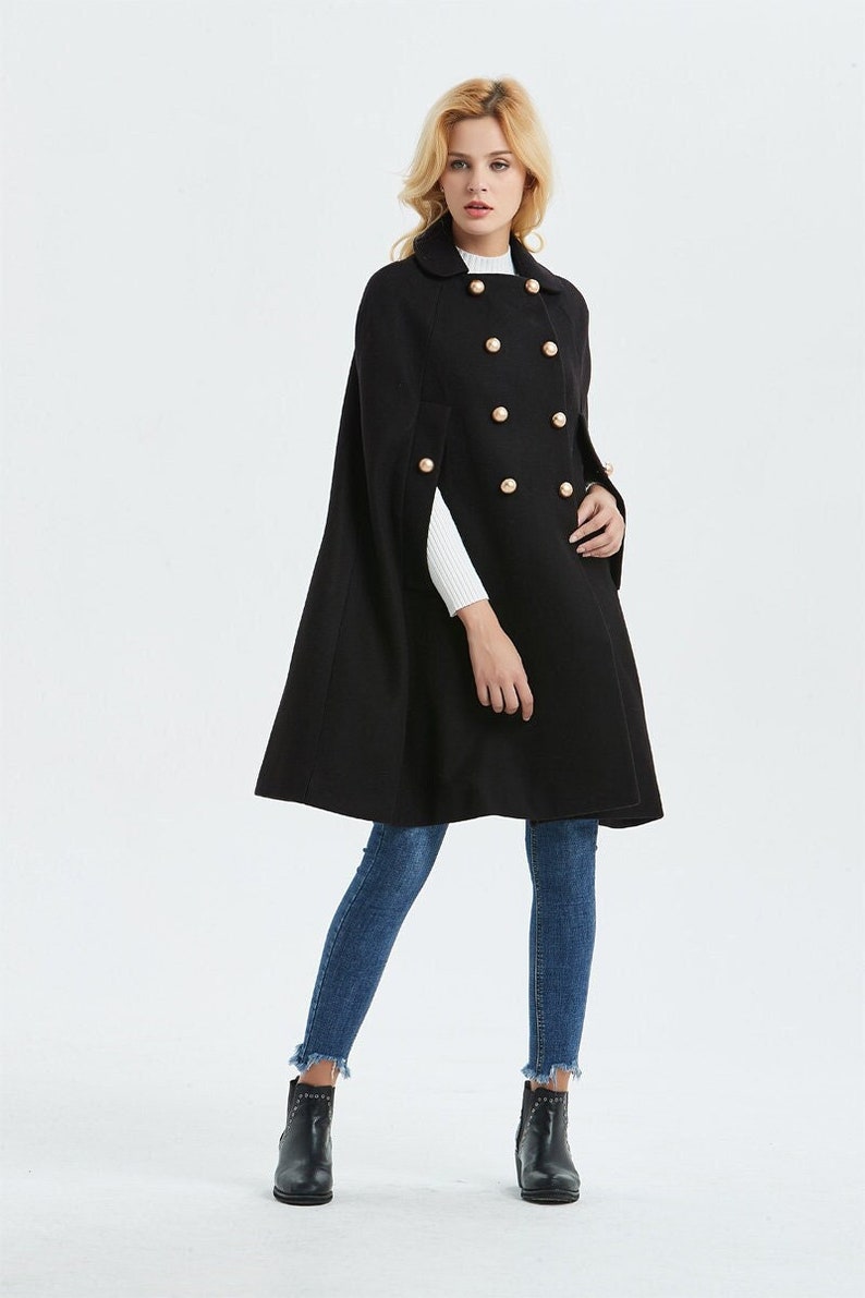 May include: A black double-breasted cape with gold buttons. The cape is knee-length and has a collar.
