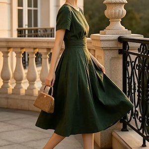 May include: A dark green midi dress with short sleeves, a round neckline, and a fitted waist. The dress is paired with a tan straw hat, a small brown structured handbag with a gold clasp, and tan high-heeled pumps with black pointed toes.