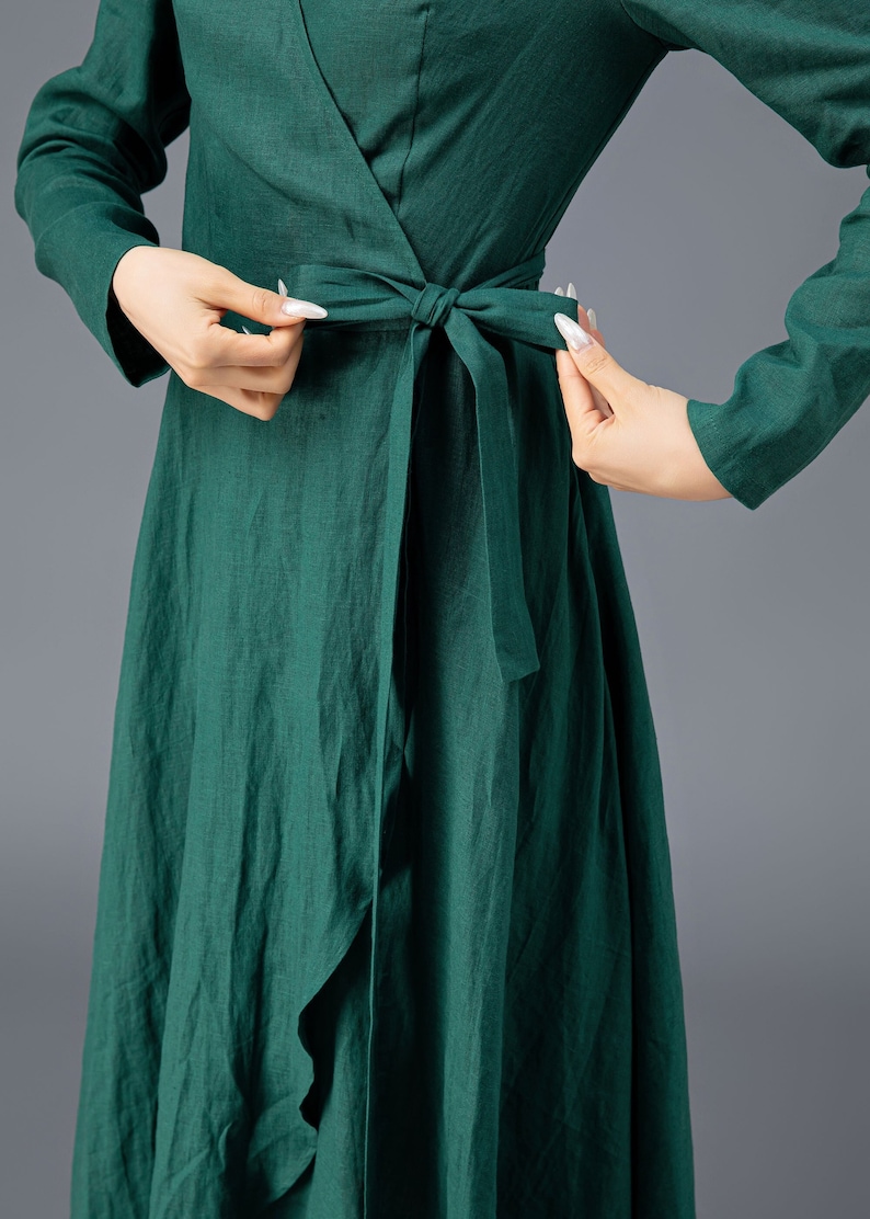 May include: A dark green wrap dress with long sleeves and a tie at the waist.
