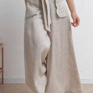 May include: Wide-leg linen pants with a tie belt and large pockets. The pants are a light beige color.