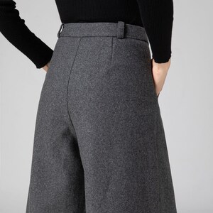 Pu&ograve; includere: Pantaloni grigi a gamba larga con vita alta e dettaglio passanti per cintura. I pantaloni sono realizzati in un tessuto morbido e testurizzato.