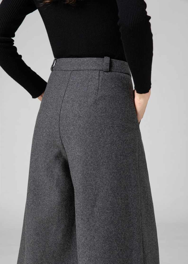 Pu&ograve; includere: Pantaloni grigi a gamba larga con vita alta e dettaglio passanti per cintura. I pantaloni sono realizzati in un tessuto morbido e testurizzato.