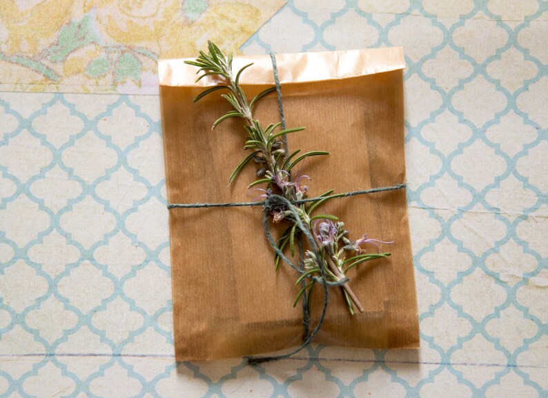 May include: A brown paper package tied with twine and decorated with a sprig of rosemary.