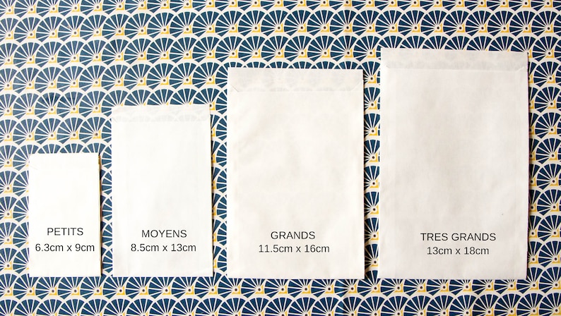 May include: Four white paper envelopes of different sizes, labeled "Petits 6.3cm x 9cm", "Moyens 8.5cm x 13cm", "Grands 11.5cm x 16cm", and "Tres Grands 13cm x 18cm". The envelopes are arranged in a row from smallest to largest on a blue and yellow patterned background.