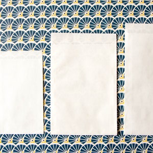 May include: Four white envelopes of different sizes on a blue and yellow patterned background.