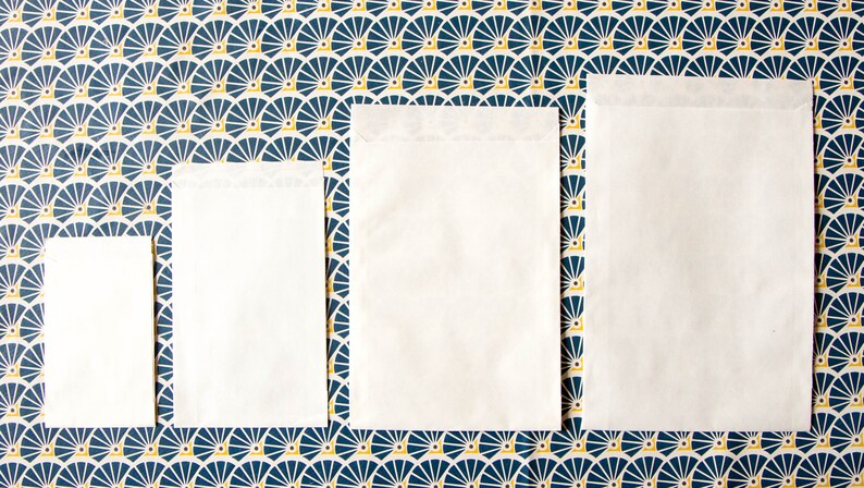 May include: Four white envelopes of different sizes on a blue and yellow patterned background.