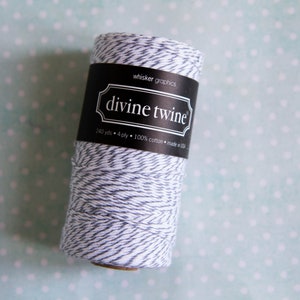 May include: A roll of white and black twine with the text "divine twine" on the label. The label also says "240 yds - 4 ply - 100% cotton - made in USA".