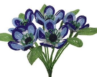 May include: A bouquet of blue, white, and green beaded flowers with green beaded leaves.