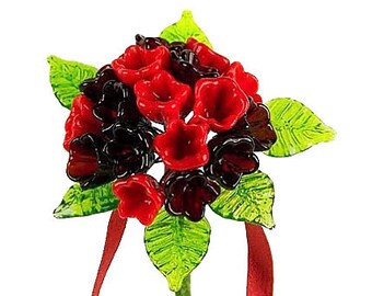 May include: A bouquet of red and black glass flowers with green leaves and a red ribbon.