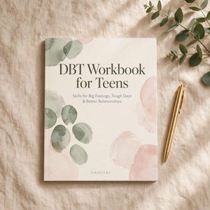 Puede incluir: Un libro de ejercicios titulado DBT Workbook for Teens: Skills for Big Feelings, Tough Days & Better Relationships. La portada presenta formas circulares estilo acuarela en verde salvia y rosa pálido junto a un bolígrafo de metal dorado.