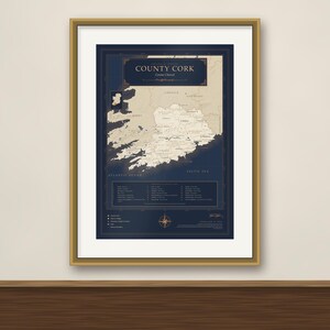 Puede incluir: Un mapa enmarcado del condado de Cork, Irlanda, con una masa terrestre de color crema sobre un fondo azul marino oscuro. La impresión incluye el texto 'COUNTY CORK', una rosa de los vientos y una leyenda detallada con varios lugares y datos.