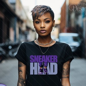 May include: A black t-shirt with a purple graphic design that says "SNEAKER HEAD" with a cartoon image of a person wearing purple sneakers.