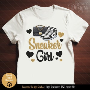 May include: A white t-shirt with a gold glitter design that says "Sneaker Girl". The design also includes a black and white sneaker and a black handbag with a gold chain.