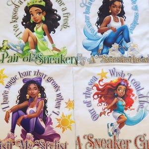 May include: Four white t-shirts with colorful graphics of Disney princesses wearing sneakers and text. The text on the shirts includes quotes from the princesses, such as "I have magic hair that grows when I wish" and "The never had a Cinderella with my sneakers!"