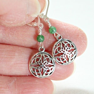 May include: Silver Celtic knot earrings with green beads hanging from the bottom. The earrings have a hook closure.
