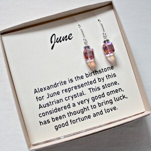 May include: A pair of silver earrings with pink and iridescent crystal stones. The earrings are in a box with a card that reads "June" and explains that alexandrite is the birthstone for June. The card also says that alexandrite is considered a very good omen and is thought to bring luck, good fortune, and love.